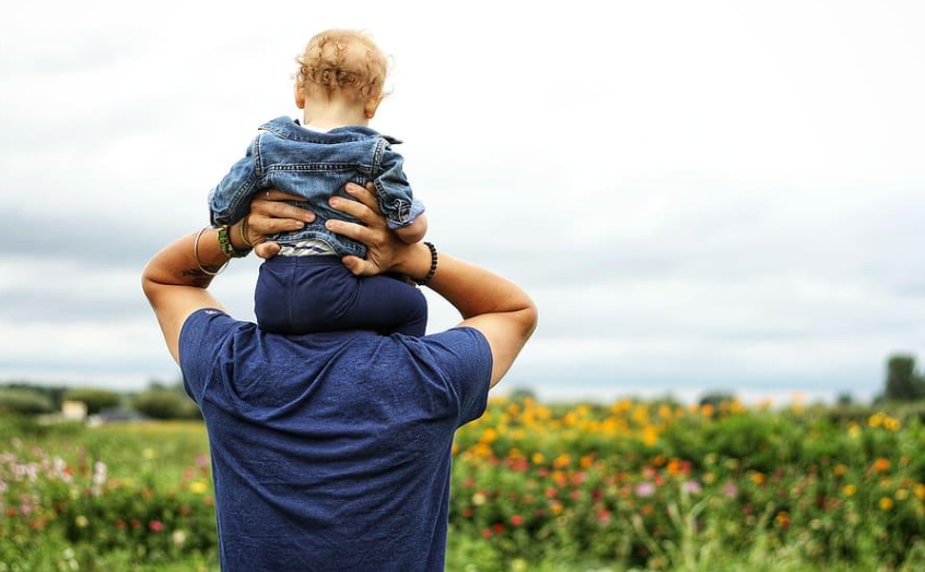 Parent carrying a child outdoors